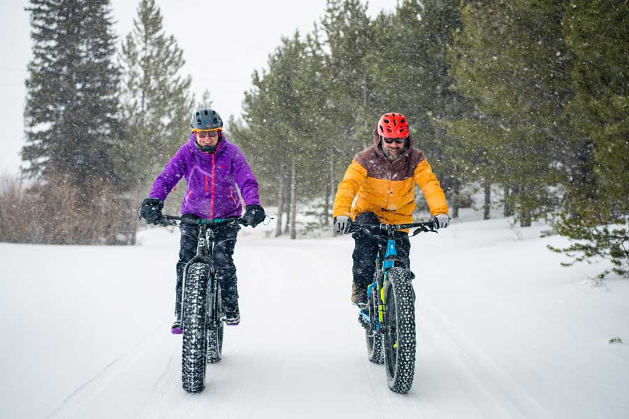 Two fat tire bike riders on a snowy trail